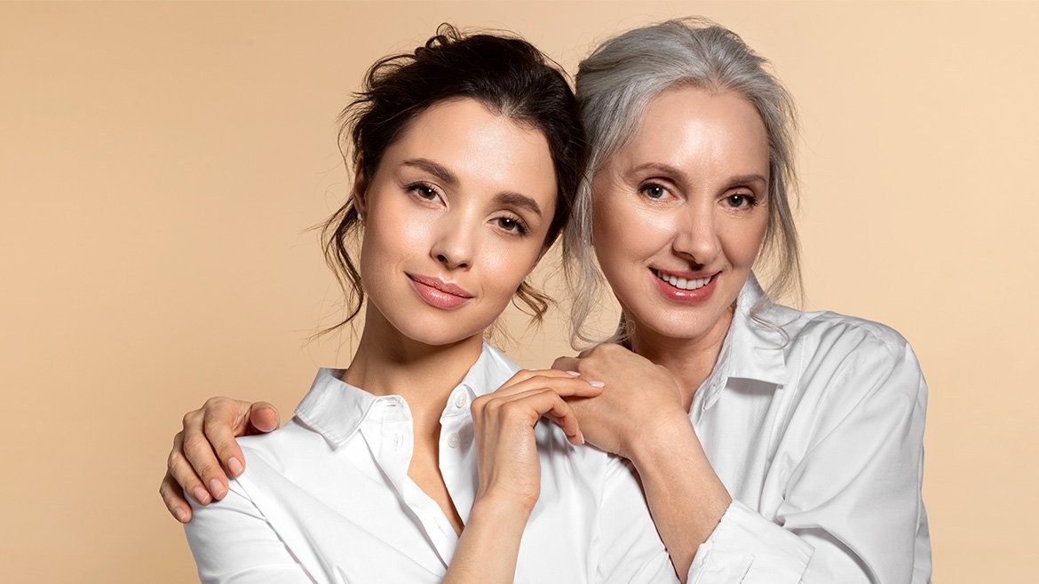 Dwie kobiety w różnym wieku stosujące serum do twarzy.